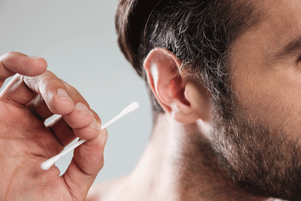 Man cleaning ears with cotton swab