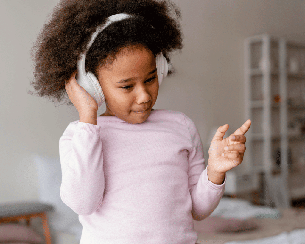 Little girl with headphones listening to music 