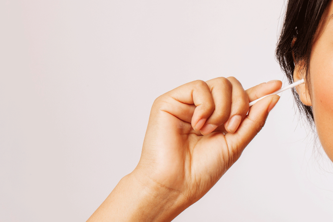 Woman cleaning ears with cotton swab